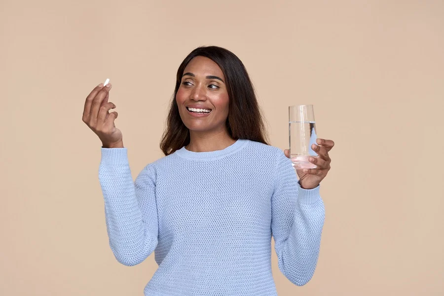 Woman taking probiotic supplement